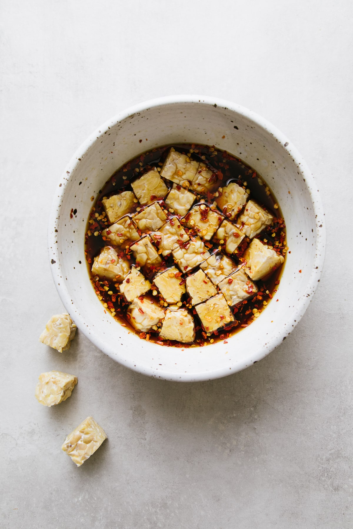 top down view of cubed tempeh in a mirin and maple marinade.