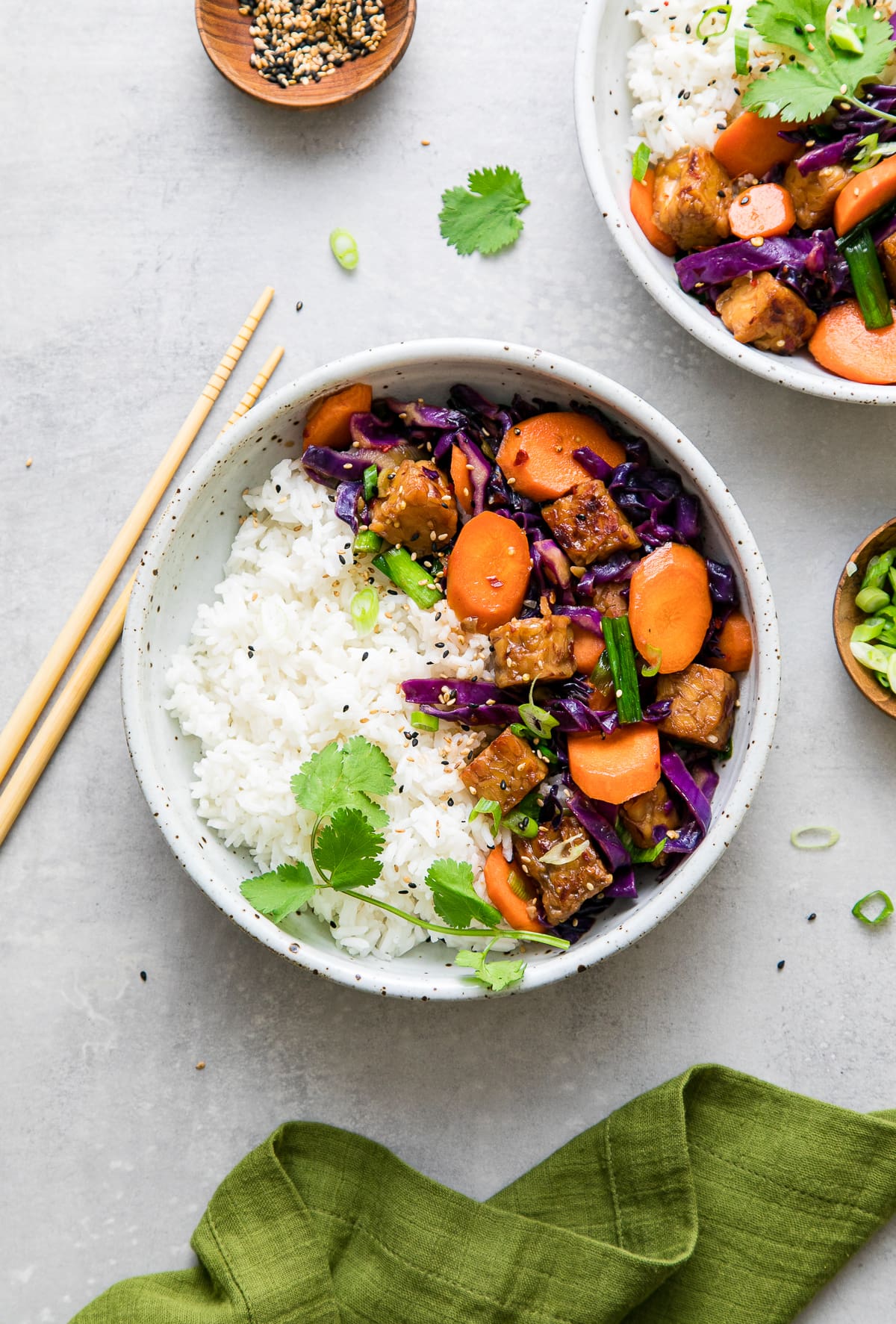 top down view of mirin maple tempeh stir fry in a bowl with rice.