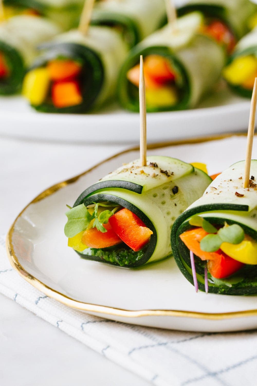 raw zucchini wraps on a white plate