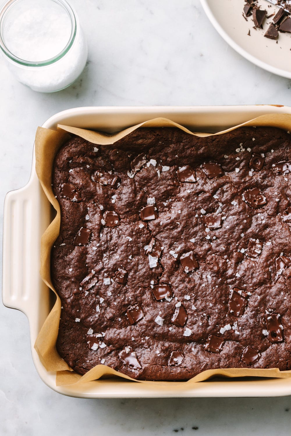 fudgy vegan brownies in a baking dish, fresh from the oven sprinkled with course salt