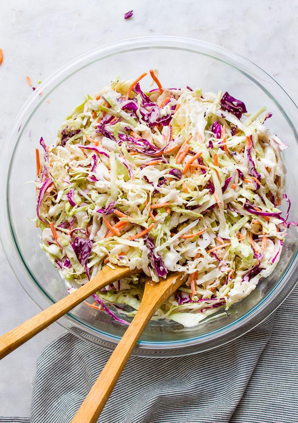 top down view of a glass mixing bowl with freshly made creamy vegan coleslaw.