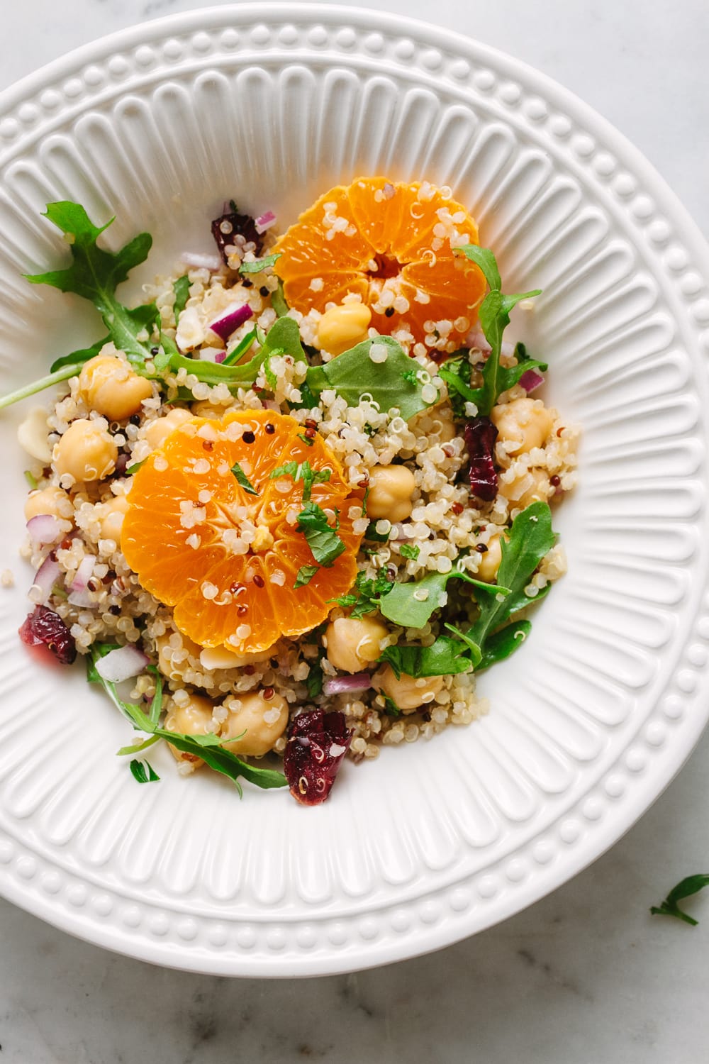 top down view of a serving of quinoa salad in a white bowl.