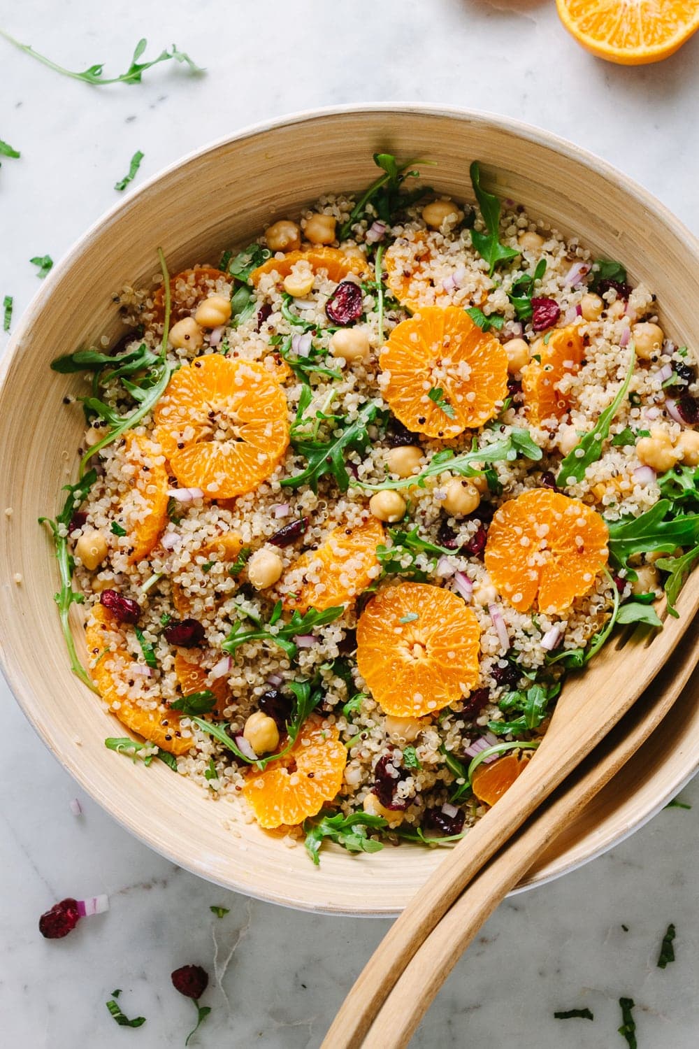 top down view of quinoa salad with orange, cranberry and mint in a large serving bowl.