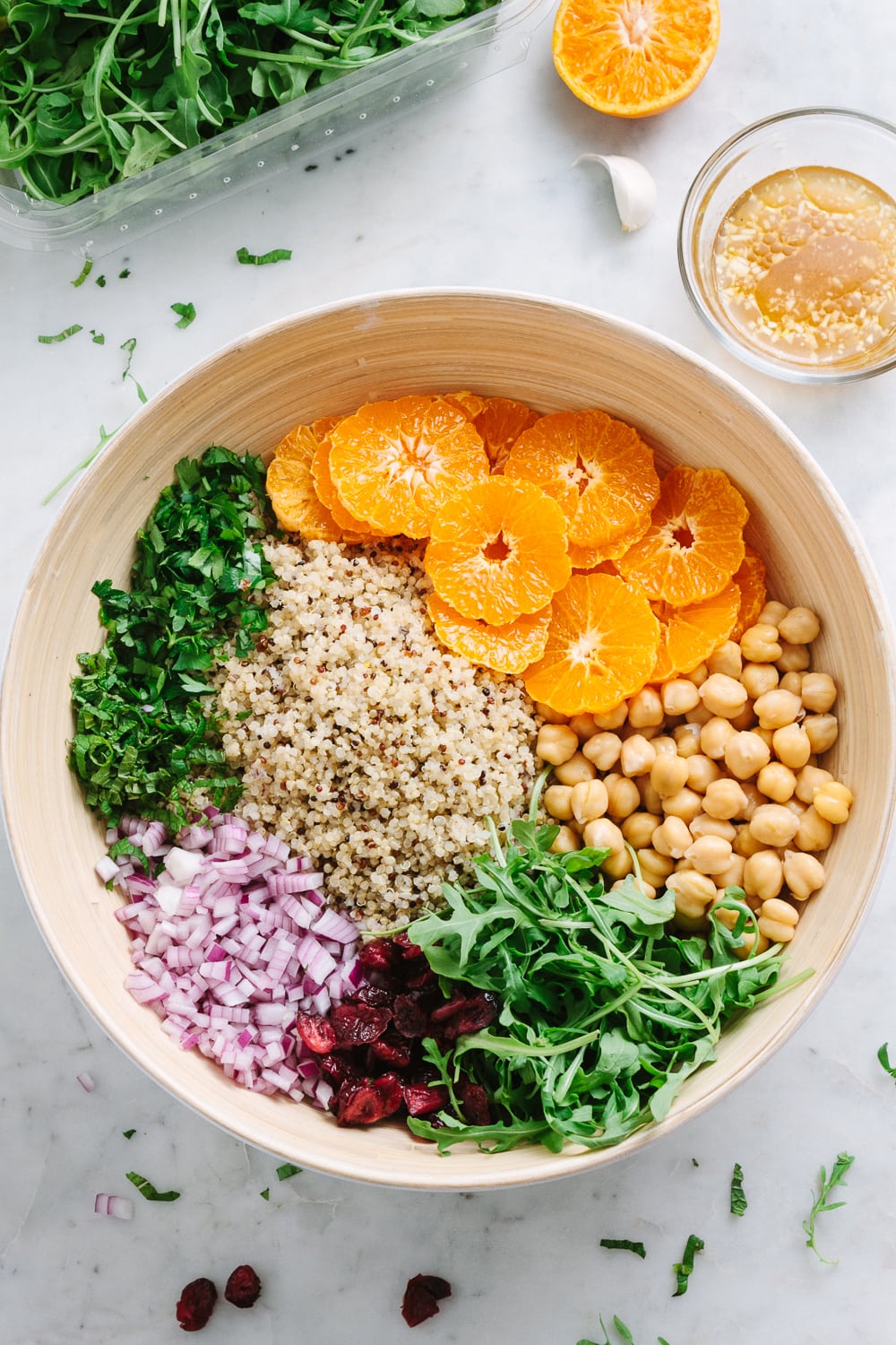 top down view of large bamboo mixing bowl filled with salad ingredients and ready to have dressing poured overtop and tossed.