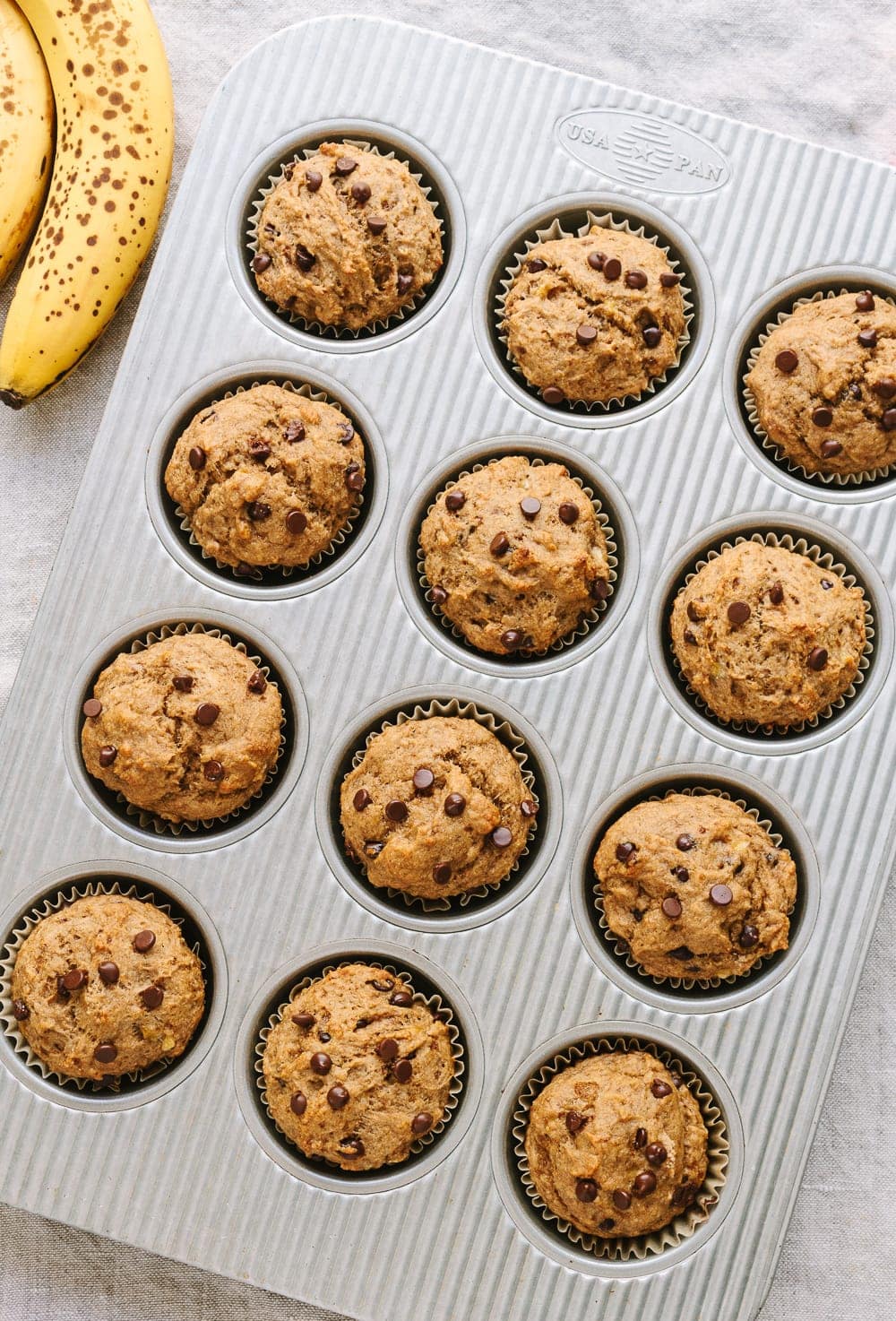 top down view of banana chocolate chip muffins in a muffin tin.