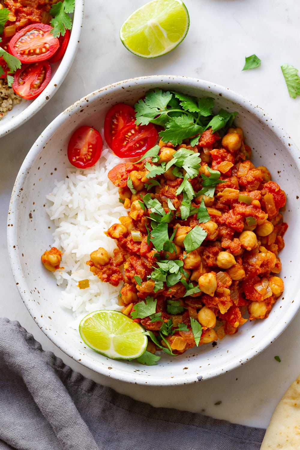 top down view of healthy chana masala in a bowl with rice, lime and cilantro.