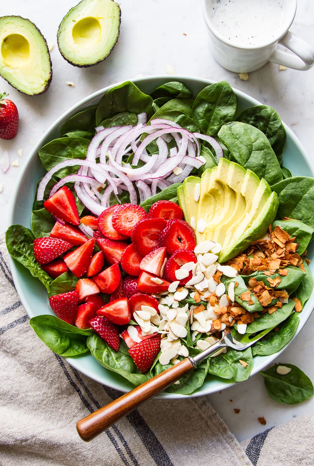 top down view of strawberry spinach salad with avocado.