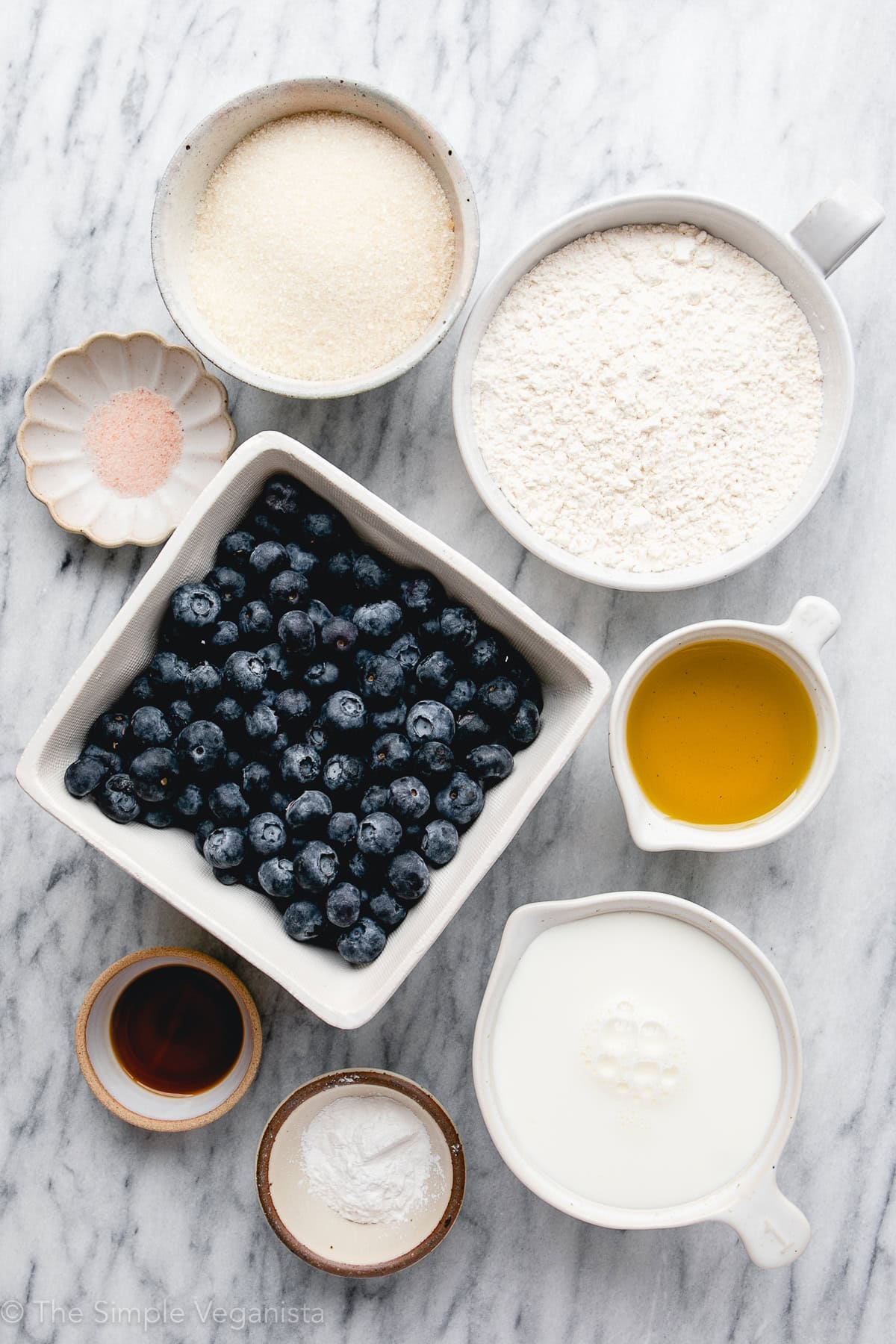 top down view of ingredients used to make vegan blueberry muffins on a marble slab.