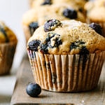 head on shot of vegan blueberry muffins on a wooden serving board.