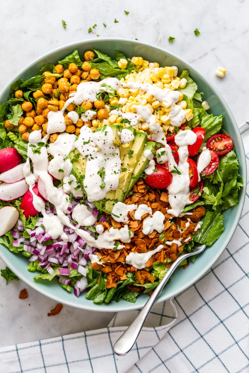 top down view of bowl filled with vegan cobb salad drizzled with vegan ranch dressing.