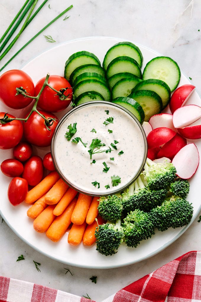 top down view of a platter plate with fresh veggies and small bowl of easy vegan ranch dressing-dip in the center.