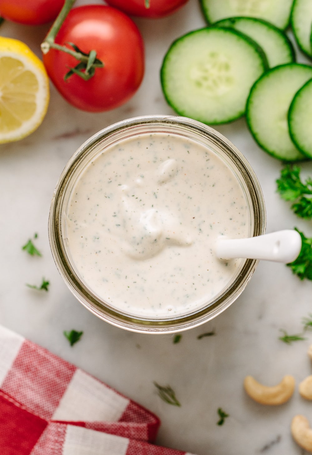 top down view of easy vegan ranch dressing in a glass mason jar with white spoon.