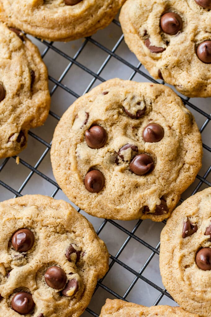 top down view of fresh baked vegan chocolate chip cookies cooling on a wire rack.