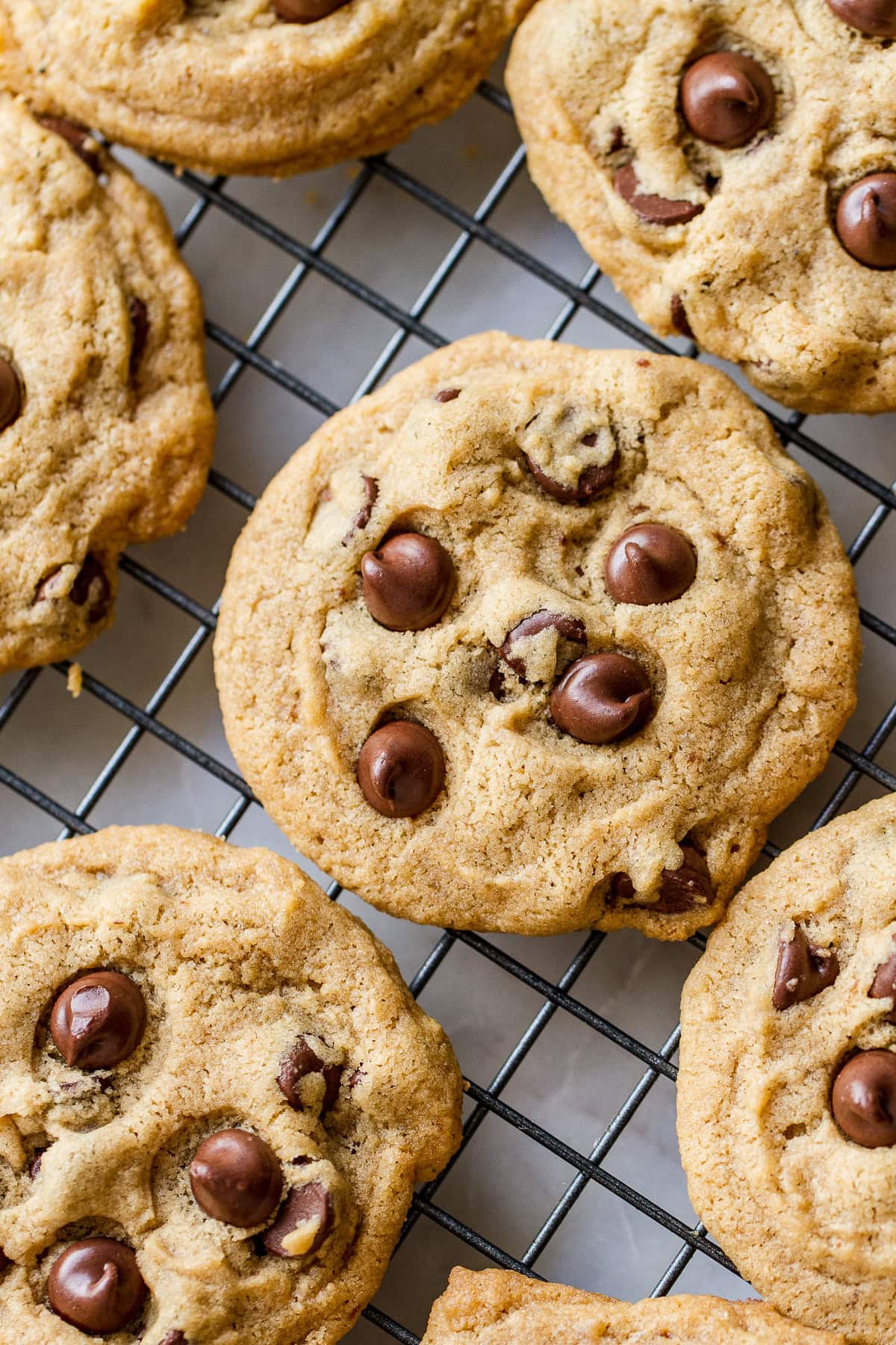 top down view of fresh baked vegan chocolate chip cookies cooling on a wire rack.