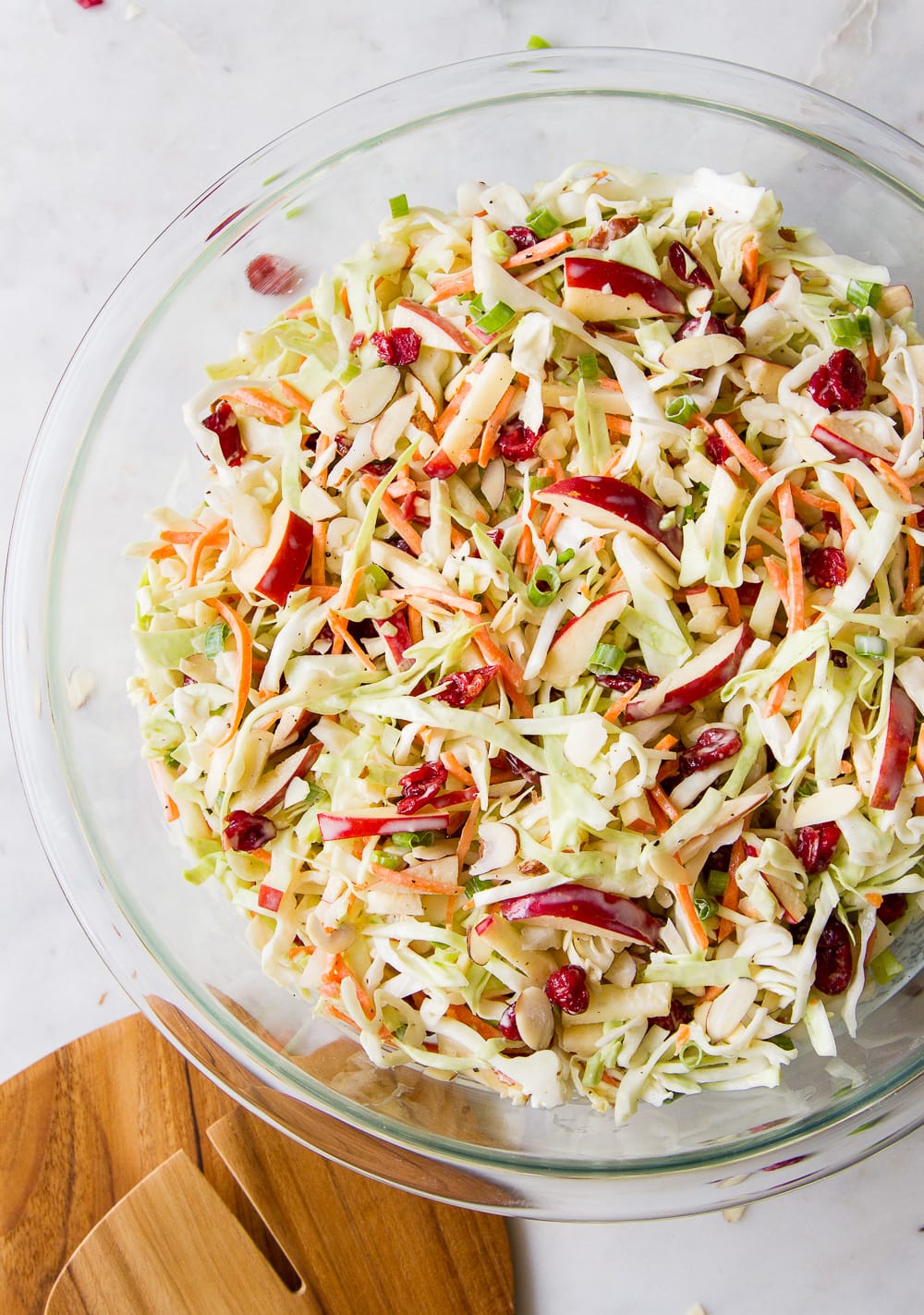 top down view of freshly mixed easy apple coleslaw in a glass bowl.