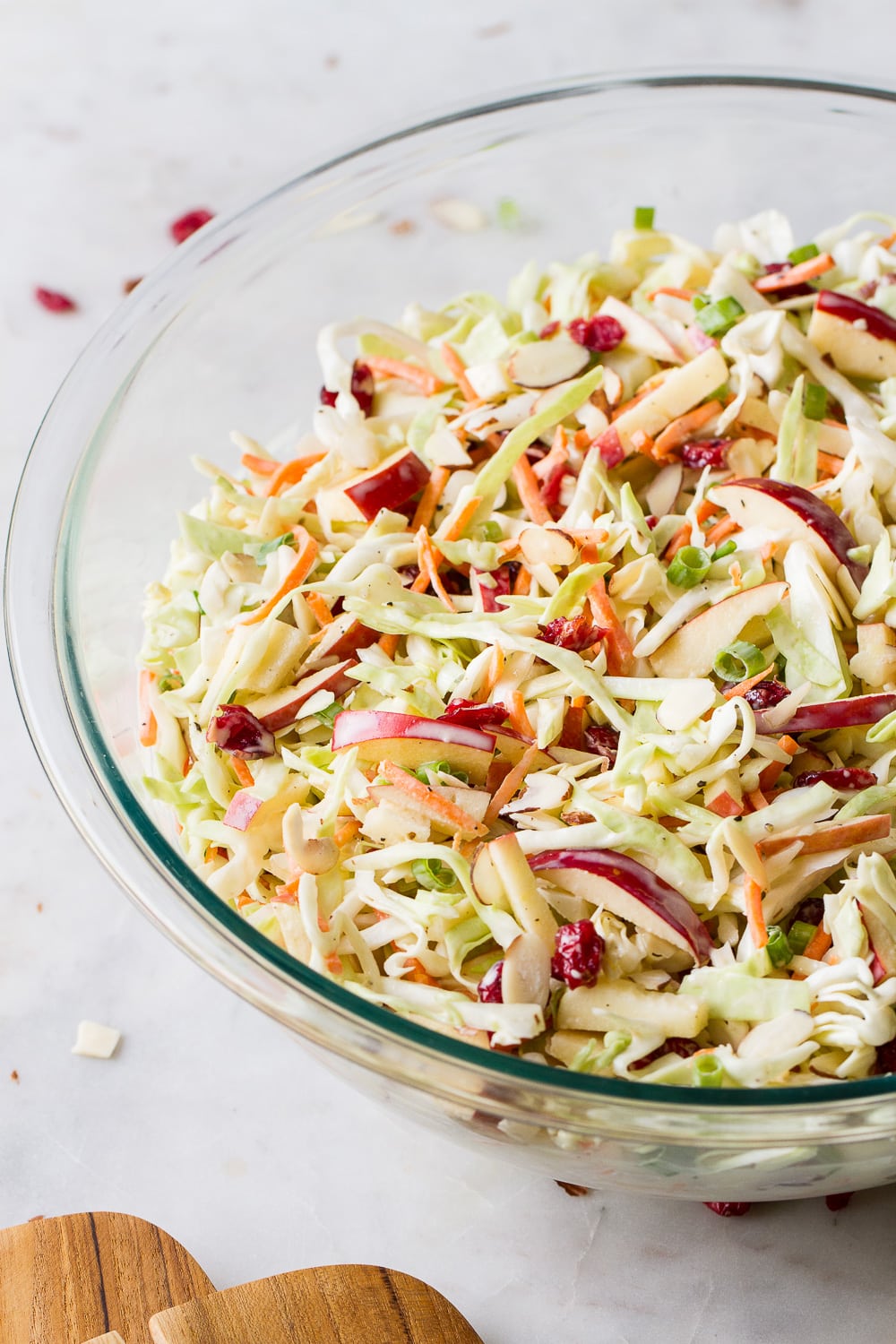 side angle view of freshly mixed easy apple coleslaw in a glass bowl.