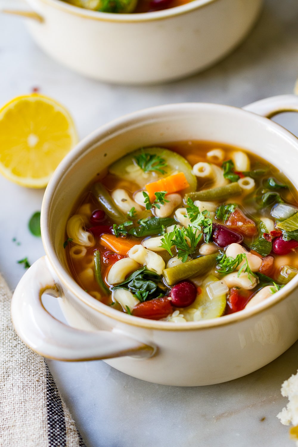 side angle view of a bowl filled with slow cooker minestrone soup.