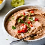 side angle view of quick and easy vegan refried beans in a bowl.