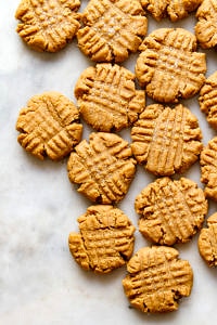 top down view of a cluster of vegan peanut butter cookies on a marble slab.