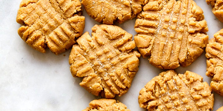 top down view of a cluster of vegan peanut butter cookies on a marble slab.