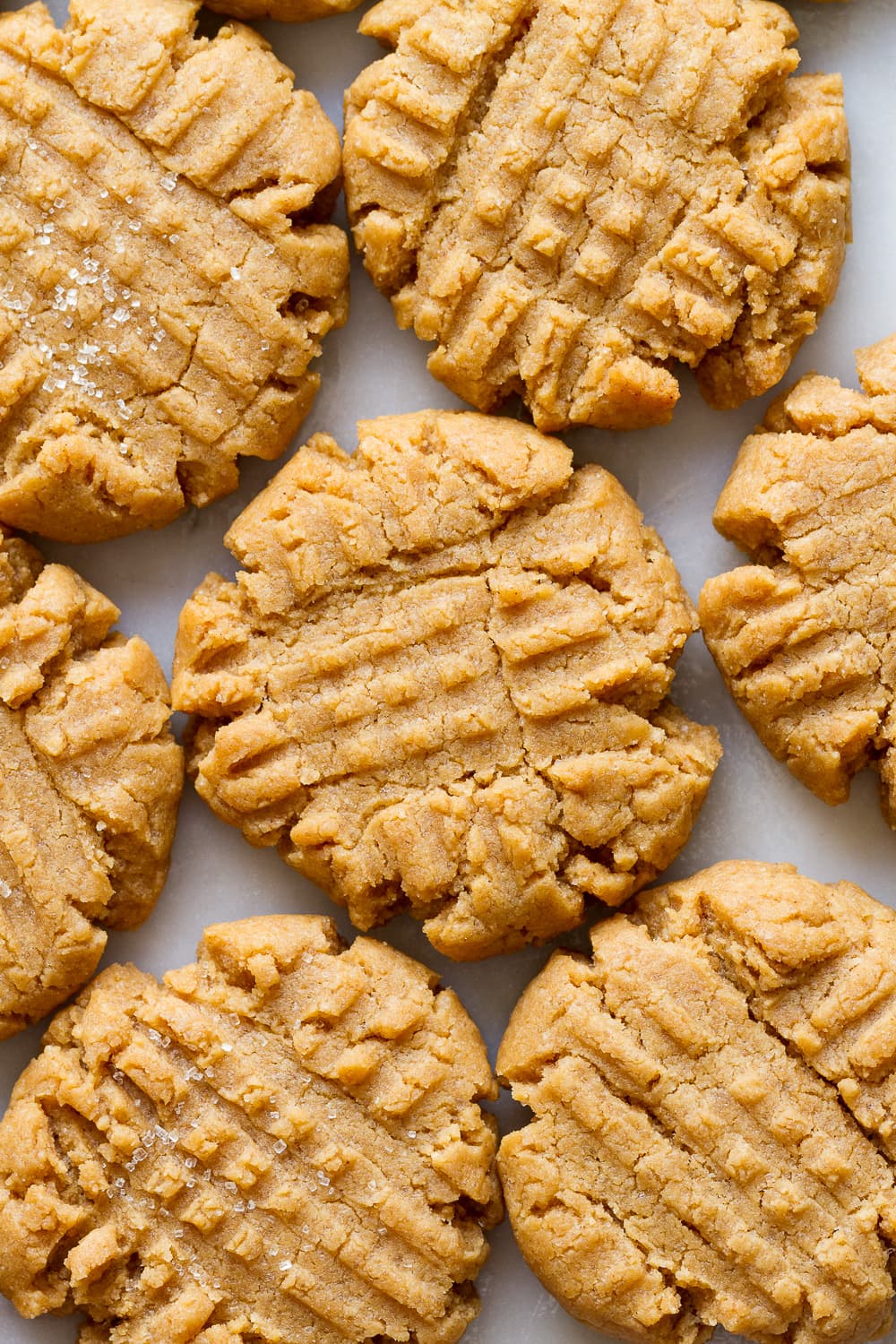 up close view of a cluster of vegan peanut butter cookies on a marble slab.