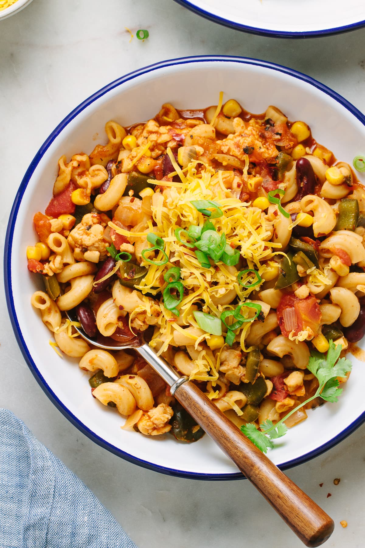 top down view of a serving of vegan chili mac in a white bowl with blue rim.