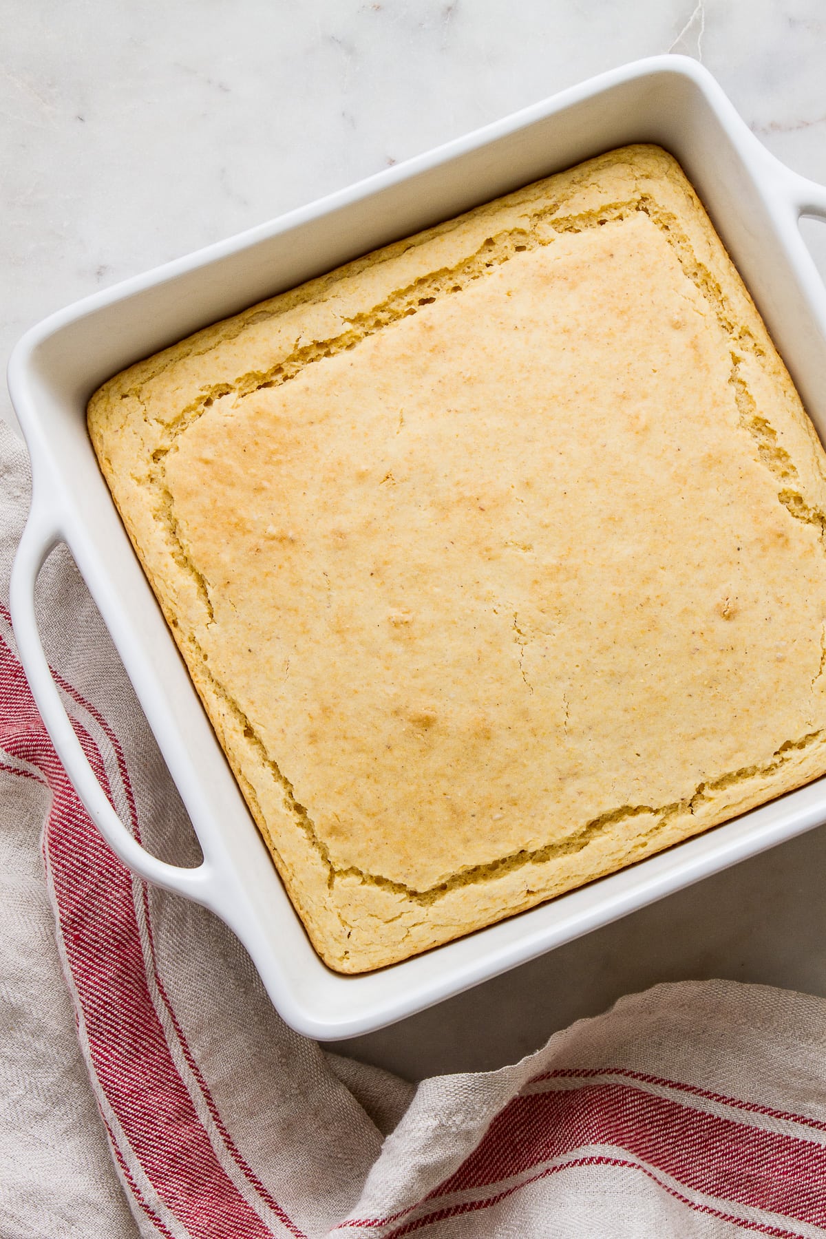 top down view of freshly baked vegan cornbread in a white baking dish.