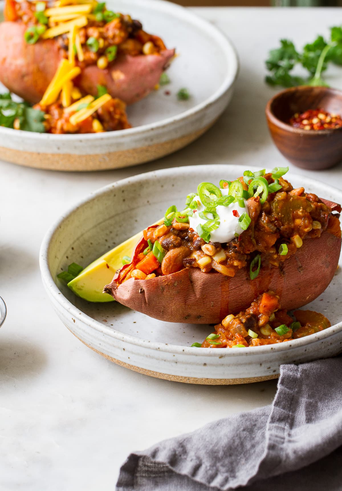 side angle view of chili stuffed sweet potato in a shallow serving bowl.