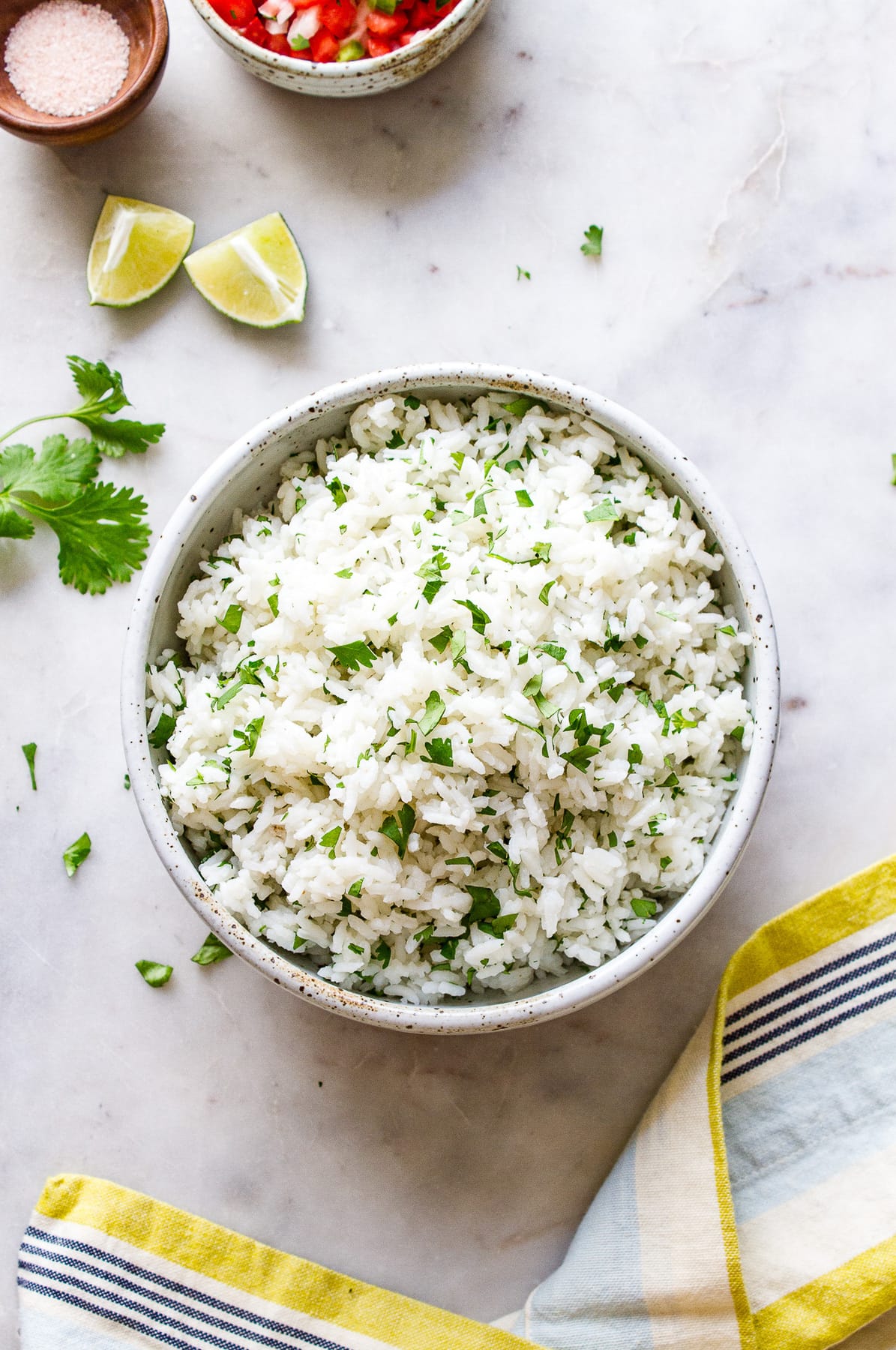 top down view of cilantro lime rice in a serving bowl with items around.