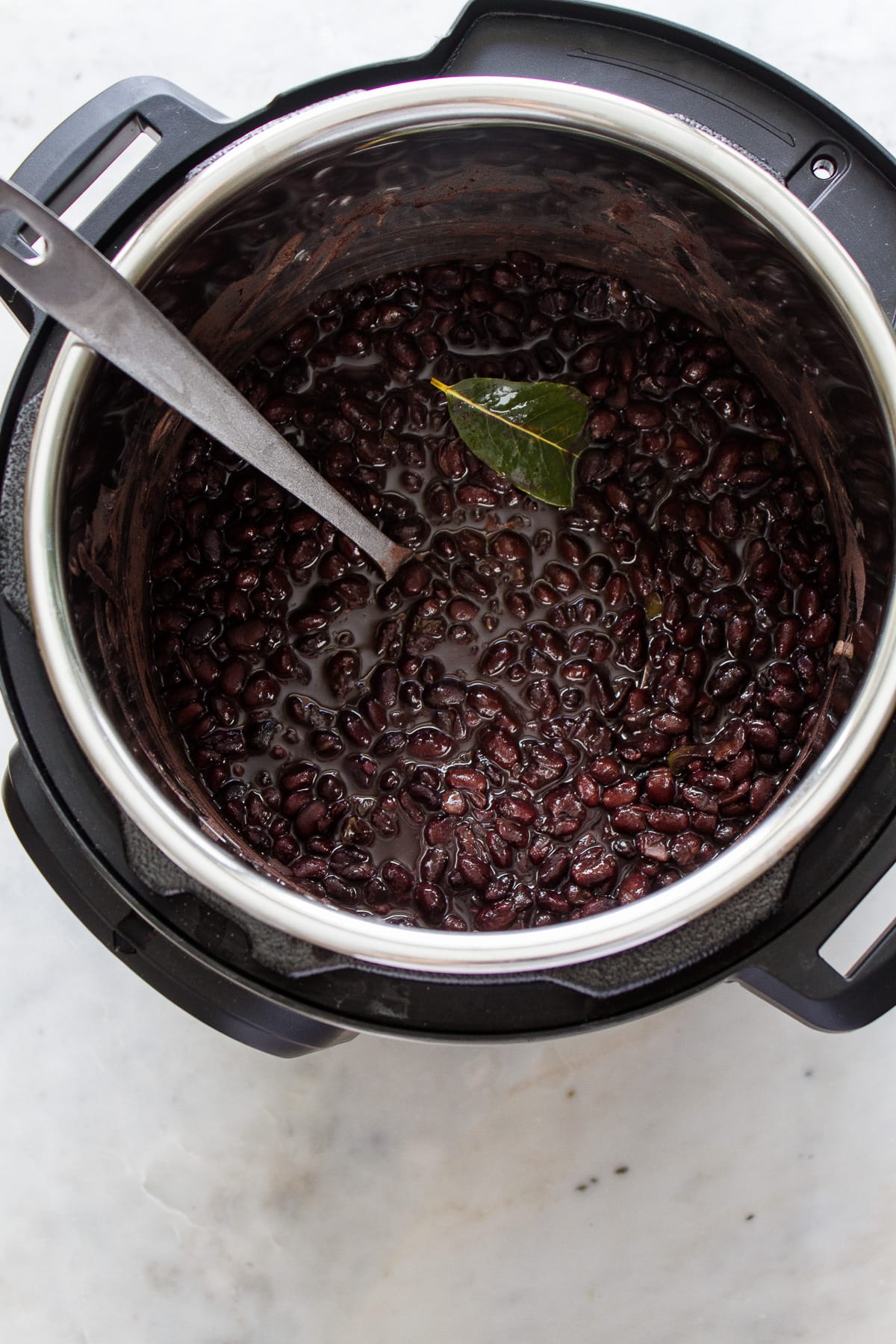 top down view of freshly cooked instant pot black beans in an instant pot with ladle.