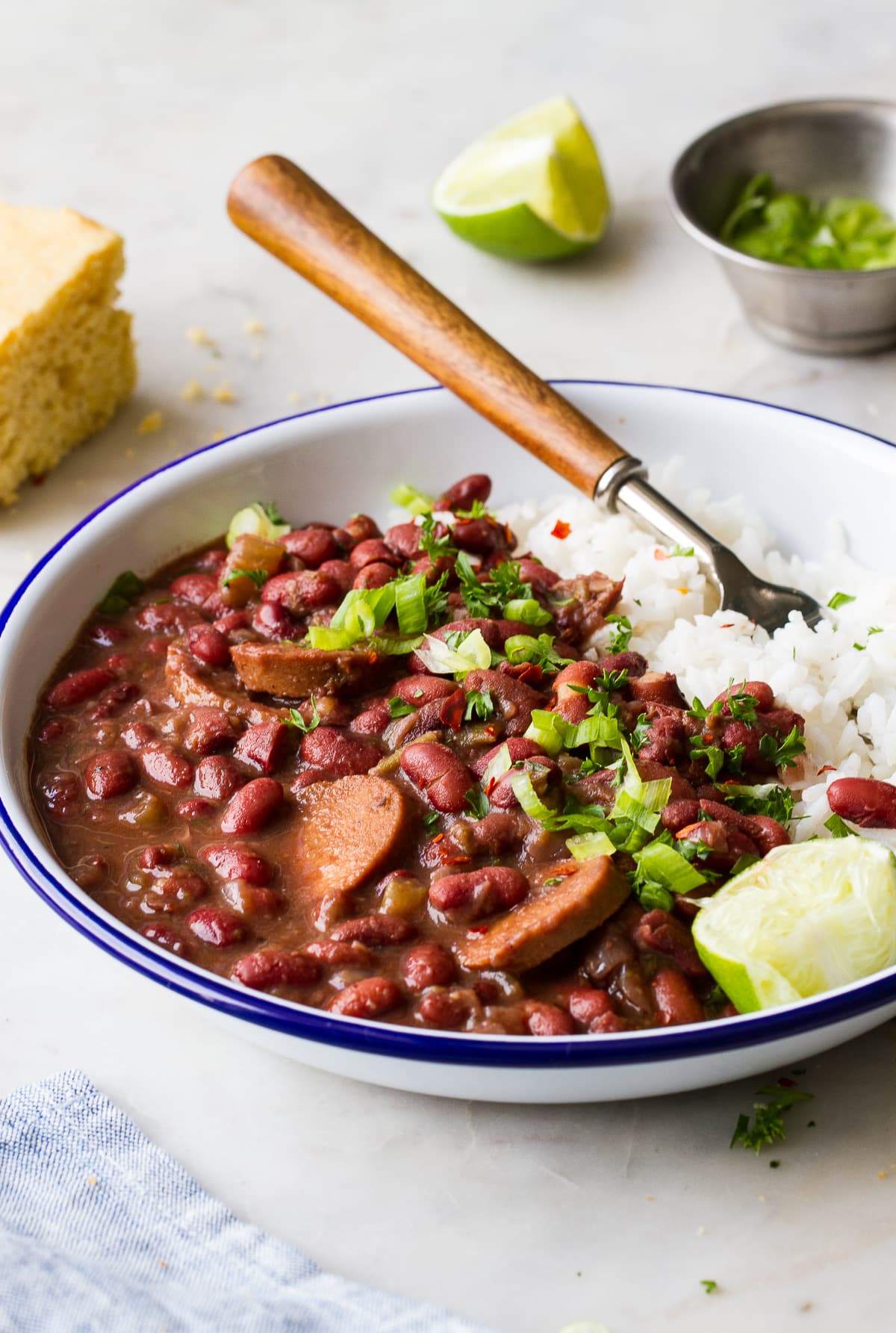 side angle view of a white bowl with blue rim filled with a serving of vegan red beans and rice.