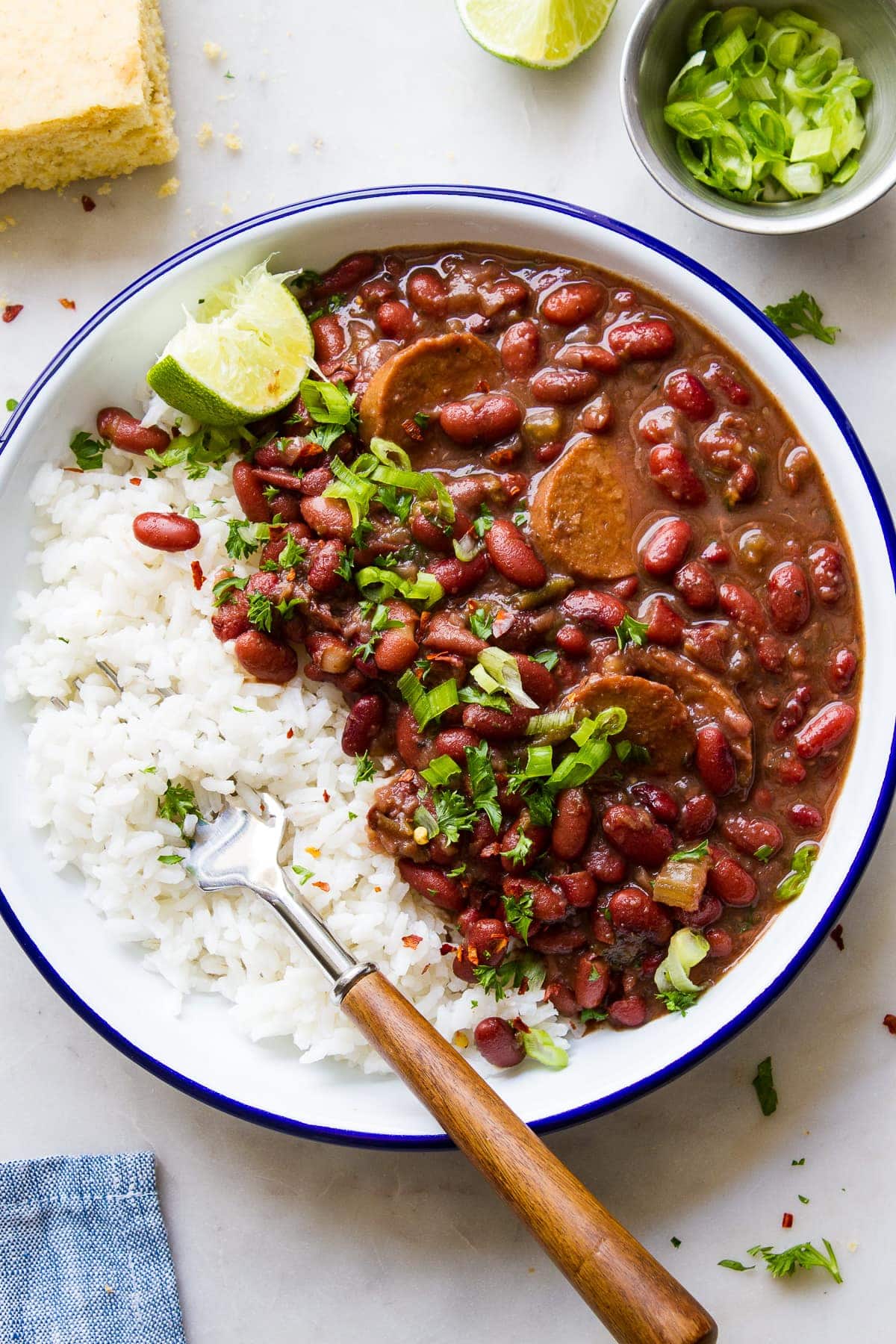 top down view of a white bowl with blue rim filled with a serving of vegan red beans and rice.