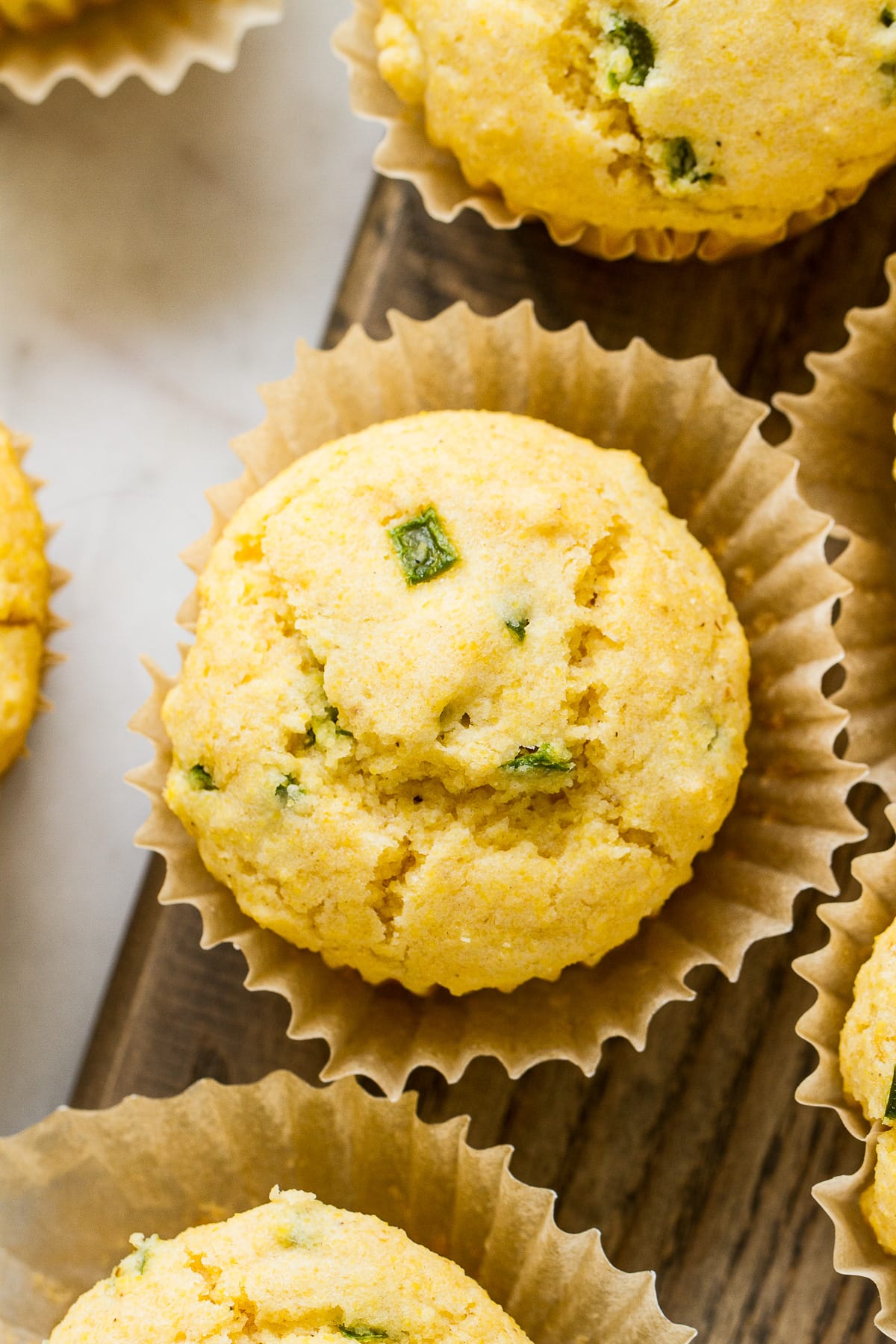 top down, up close, view of vegan corn muffins with jalapenos surrounded by other corn muffins.