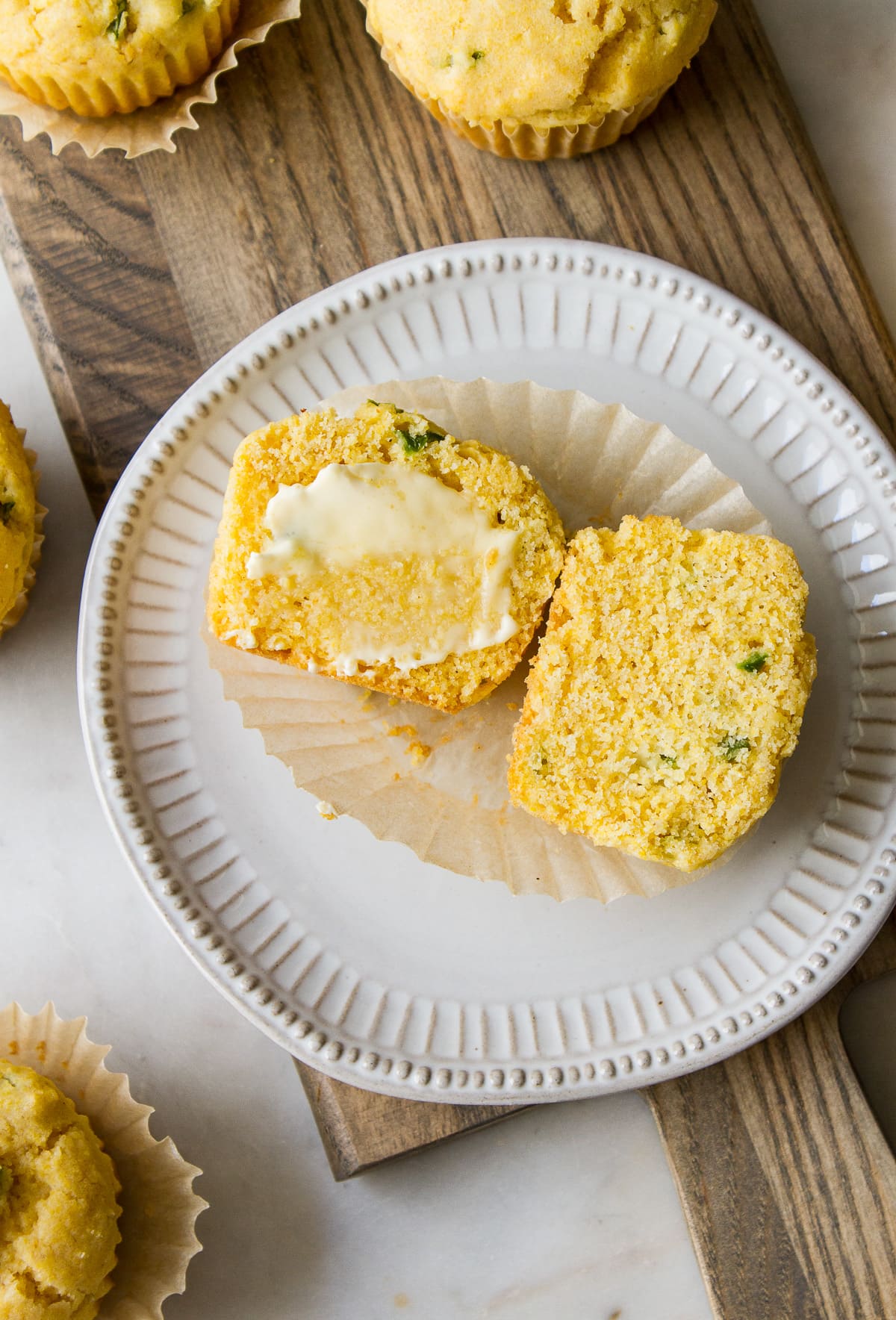 top down view of vegan corn muffin with jalapenos sliced in half and smeared with butter.