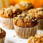 head of view of freshly made vegan pumpkin muffins resting on a serving board.