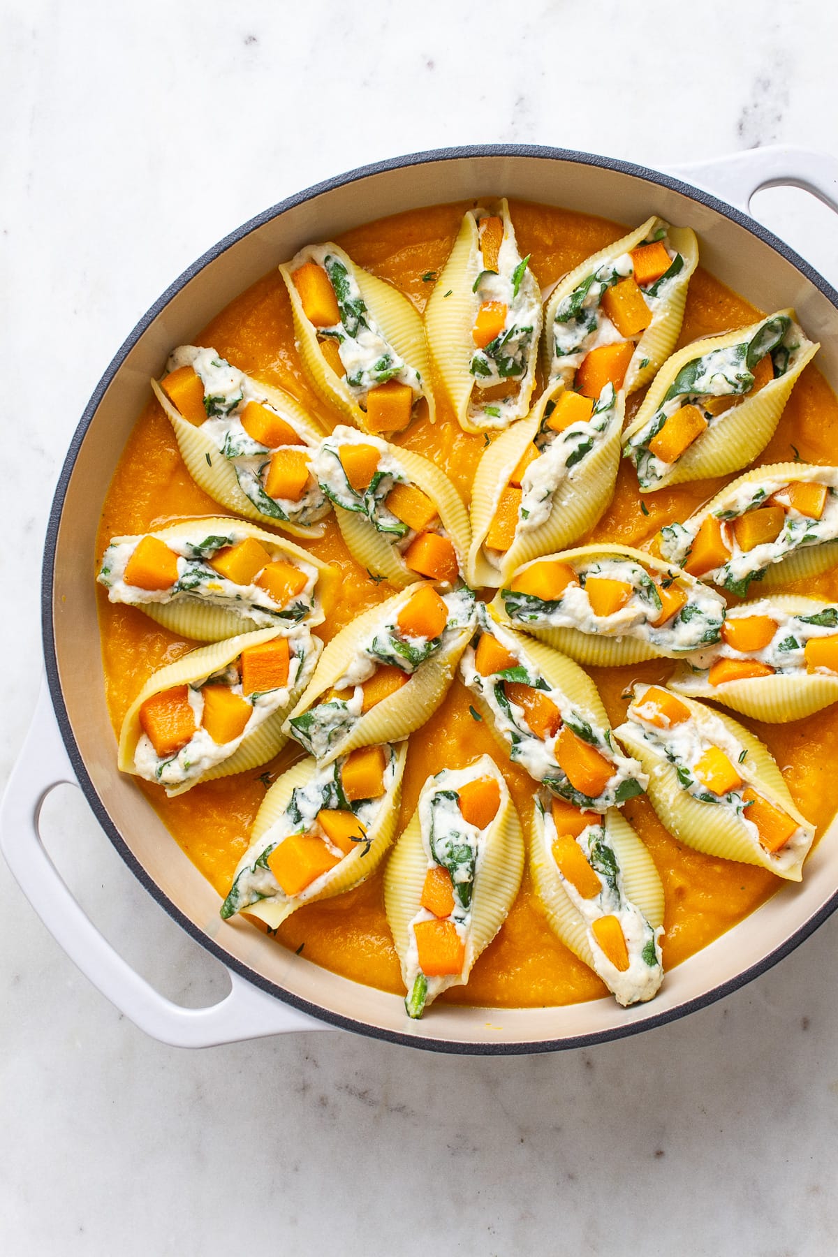 top down view of a casserole with freshly made butternut squash stuffed shells.
