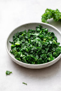 side angle view of sauteed kale in a bowl.