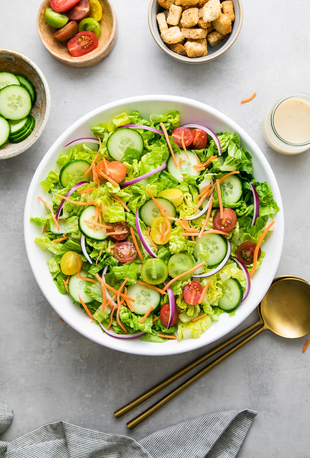 top down view of freshly assembled house salad with items surrounding.