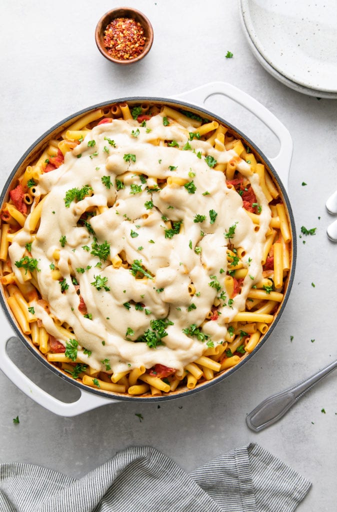 top down view of freshly made vegan baked ziti with items surrounding.