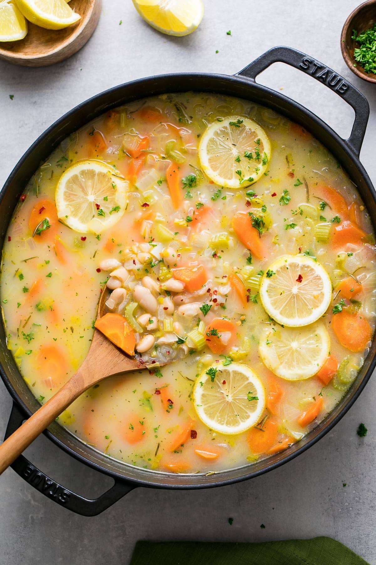 top down view of easy white bean soup in a pot with wooden spoon.