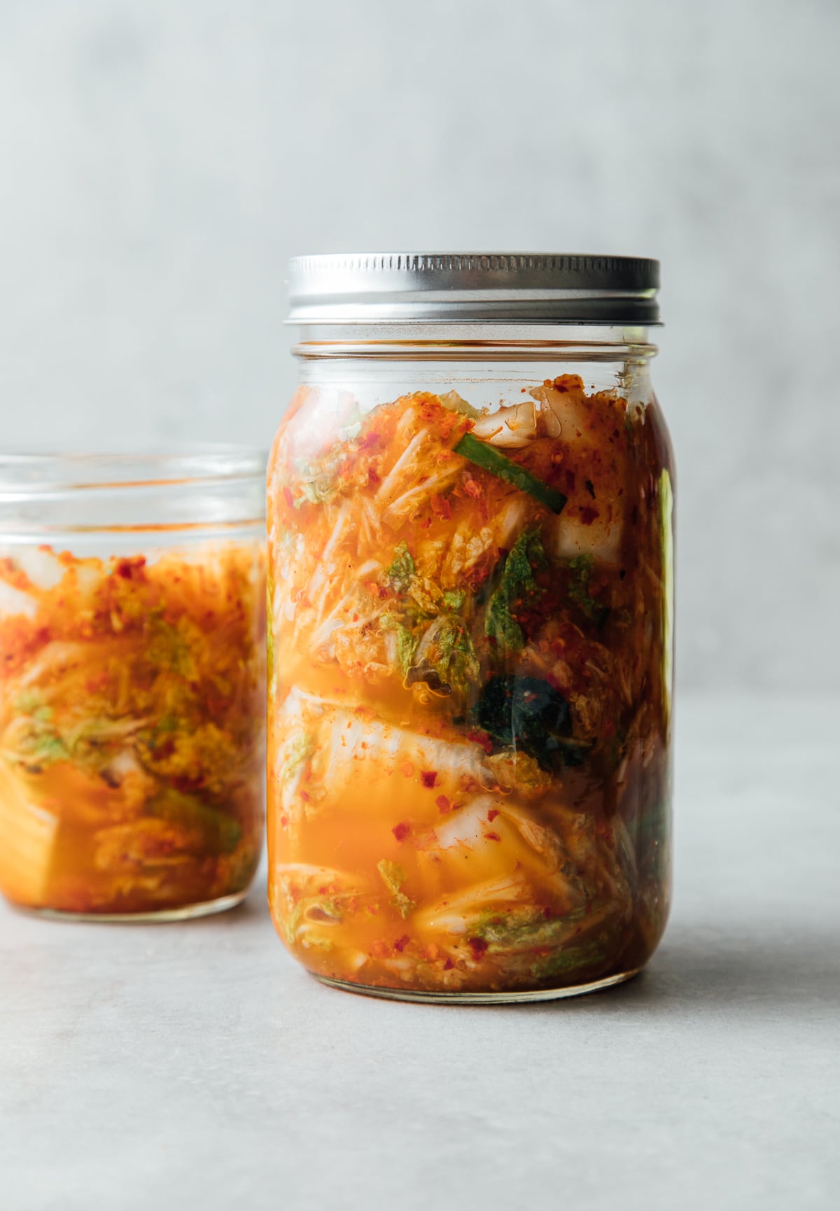 head on view of freshly mixed kimchi added to mason jar before fermenting.