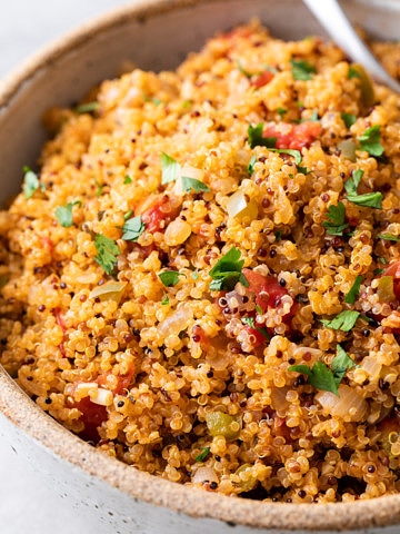 up close, side angle view of healthy quinoa Spanish rice in a serving bowl.