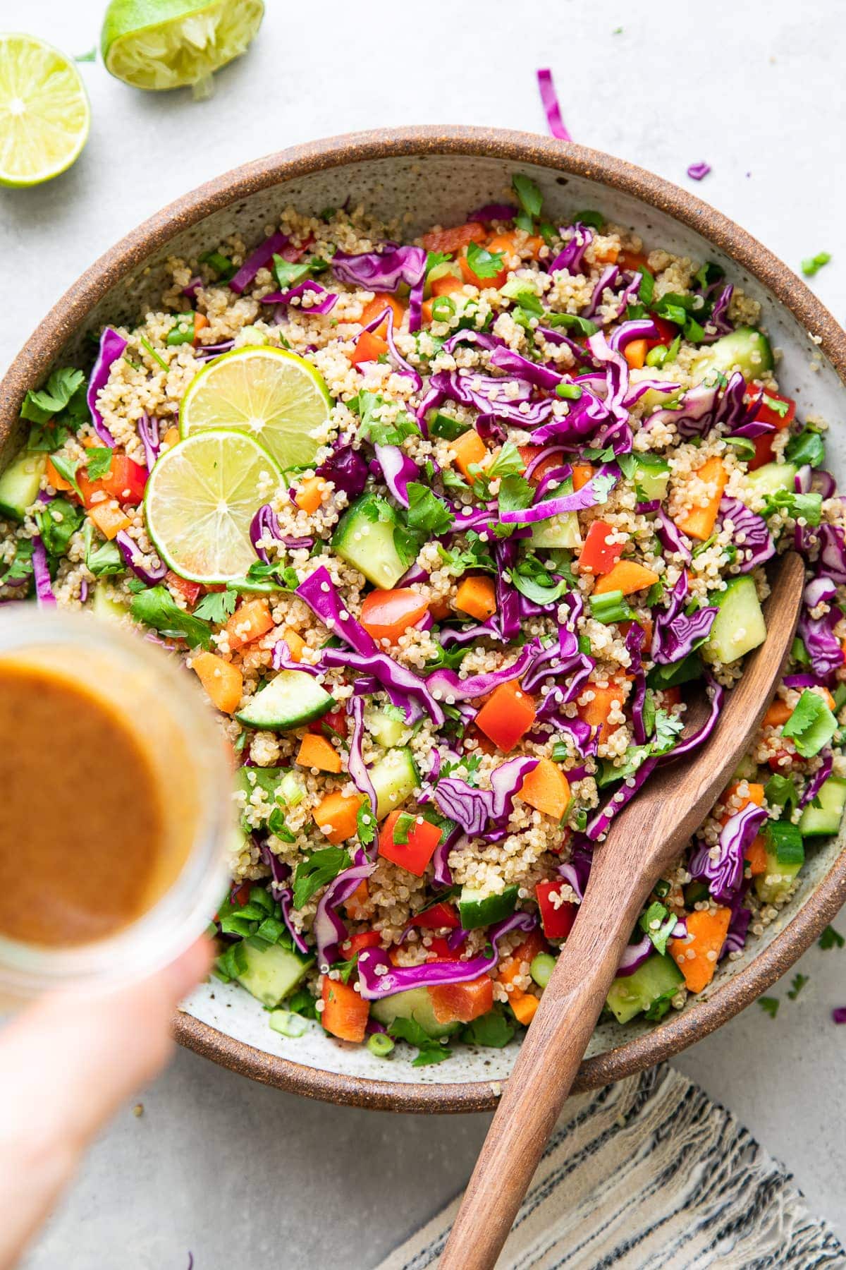 top down view of Thai quinoa salad with almond dressing about to poured overtop.