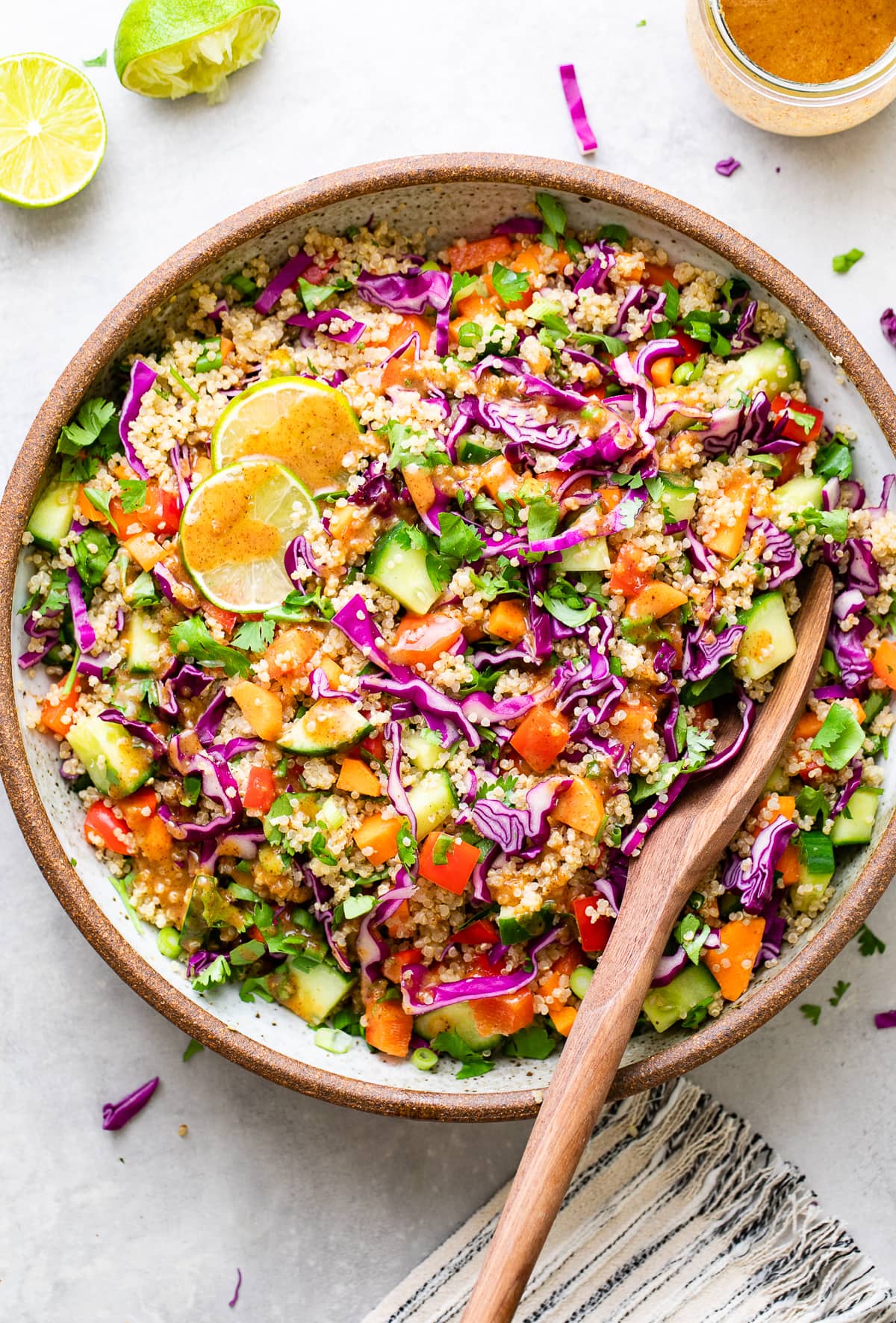 top down view of healthy Thai quinoa salad in a bowl with serving spoon.