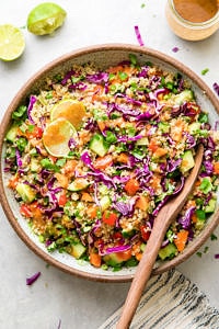 top down view of healthy Thai quinoa salad in a bowl with serving spoon.
