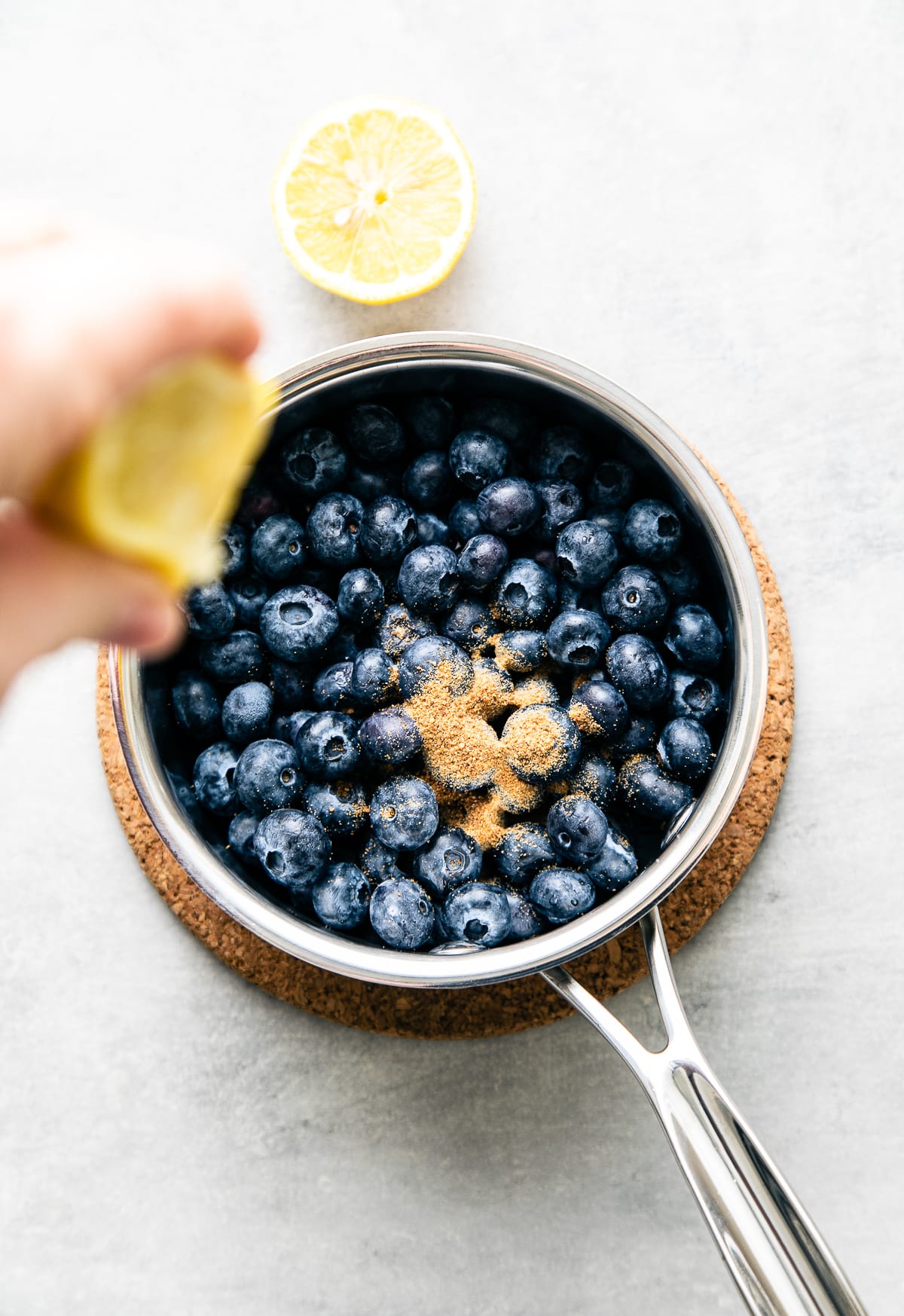 top down view showing the process of adding ingredients to pan to make blueberry compote.