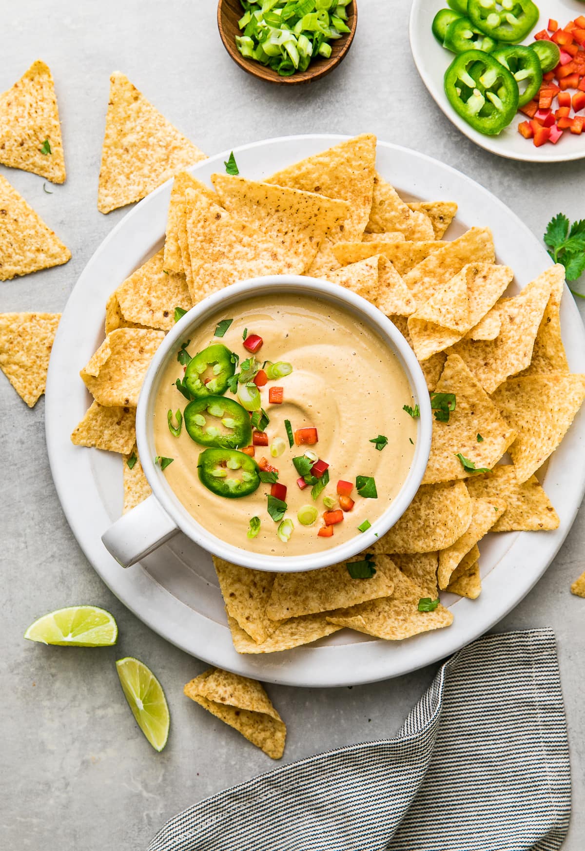 top down view of bowl of the best vegan queso in a bowl with chips surrounding.