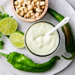 top down view of creamy hatch chile dressing in glass jar with items surrounding.