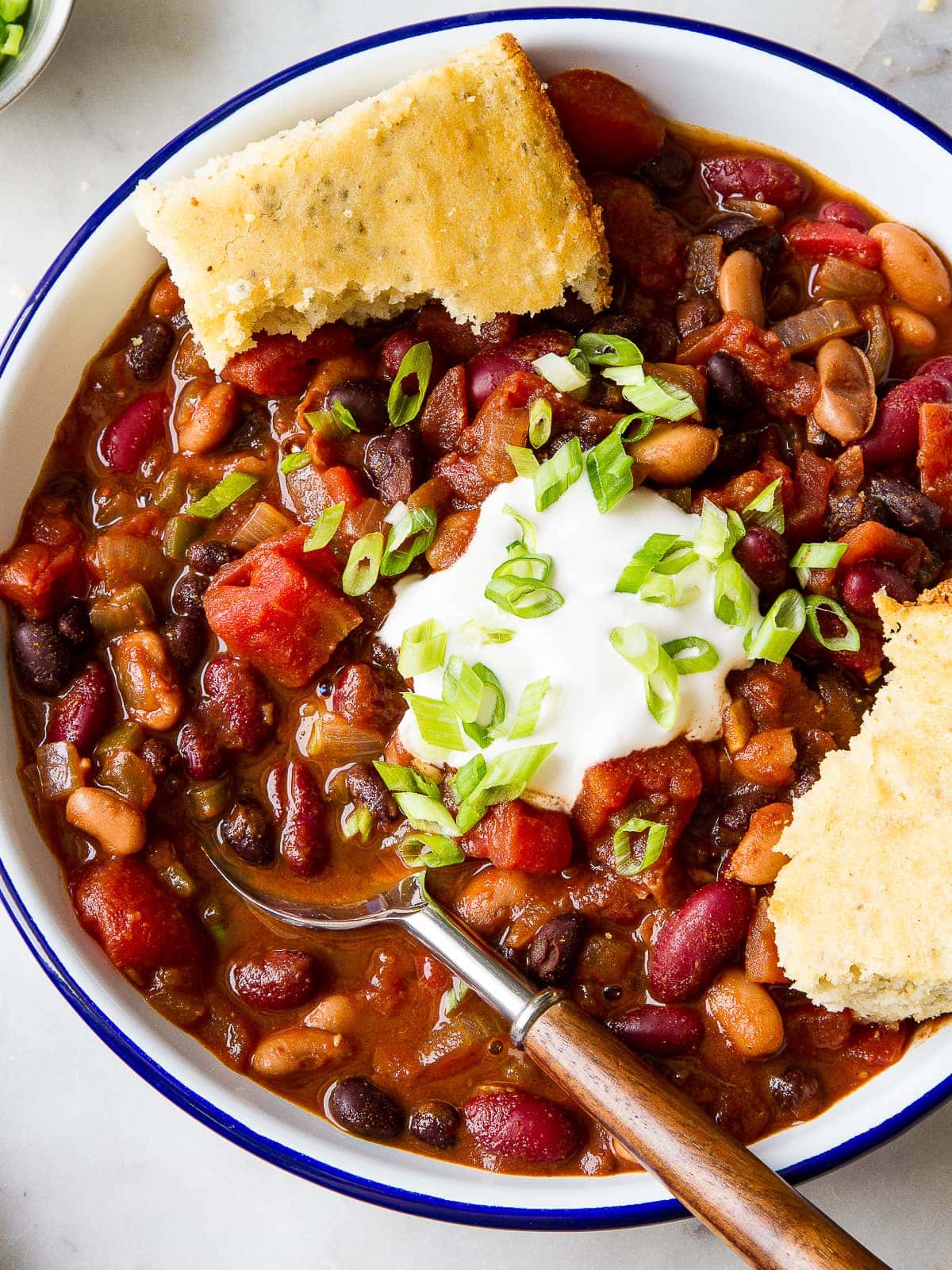 top down view of easy three bean chili plated with a spoon.