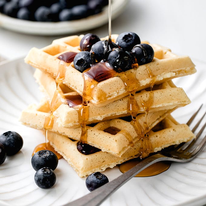 head on view of easy vegan waffles with blueberries and syrup.